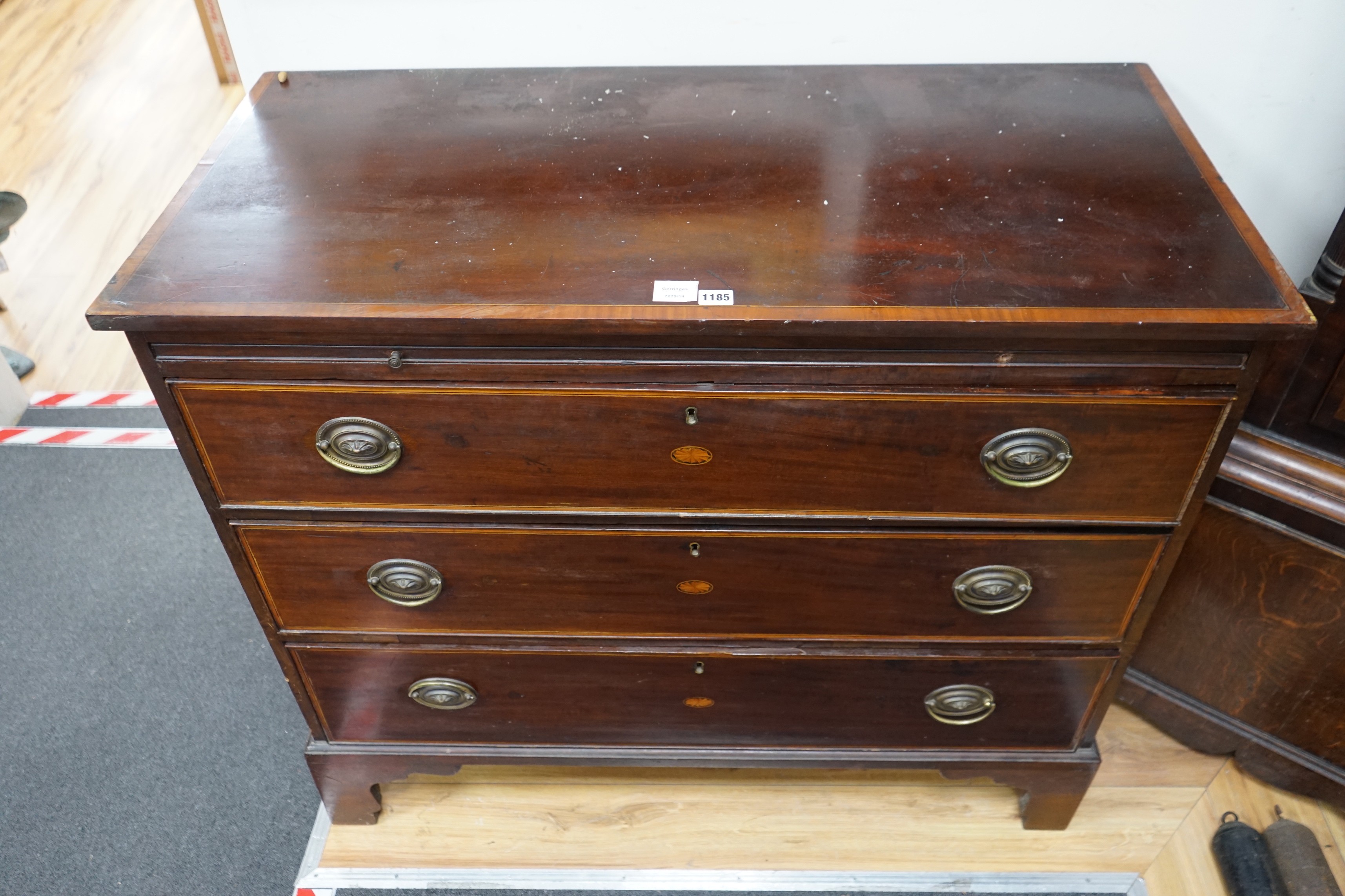 A George III inlaid mahogany three drawer chest with brushing slide, width 109cm, depth 52cm, height 74cm